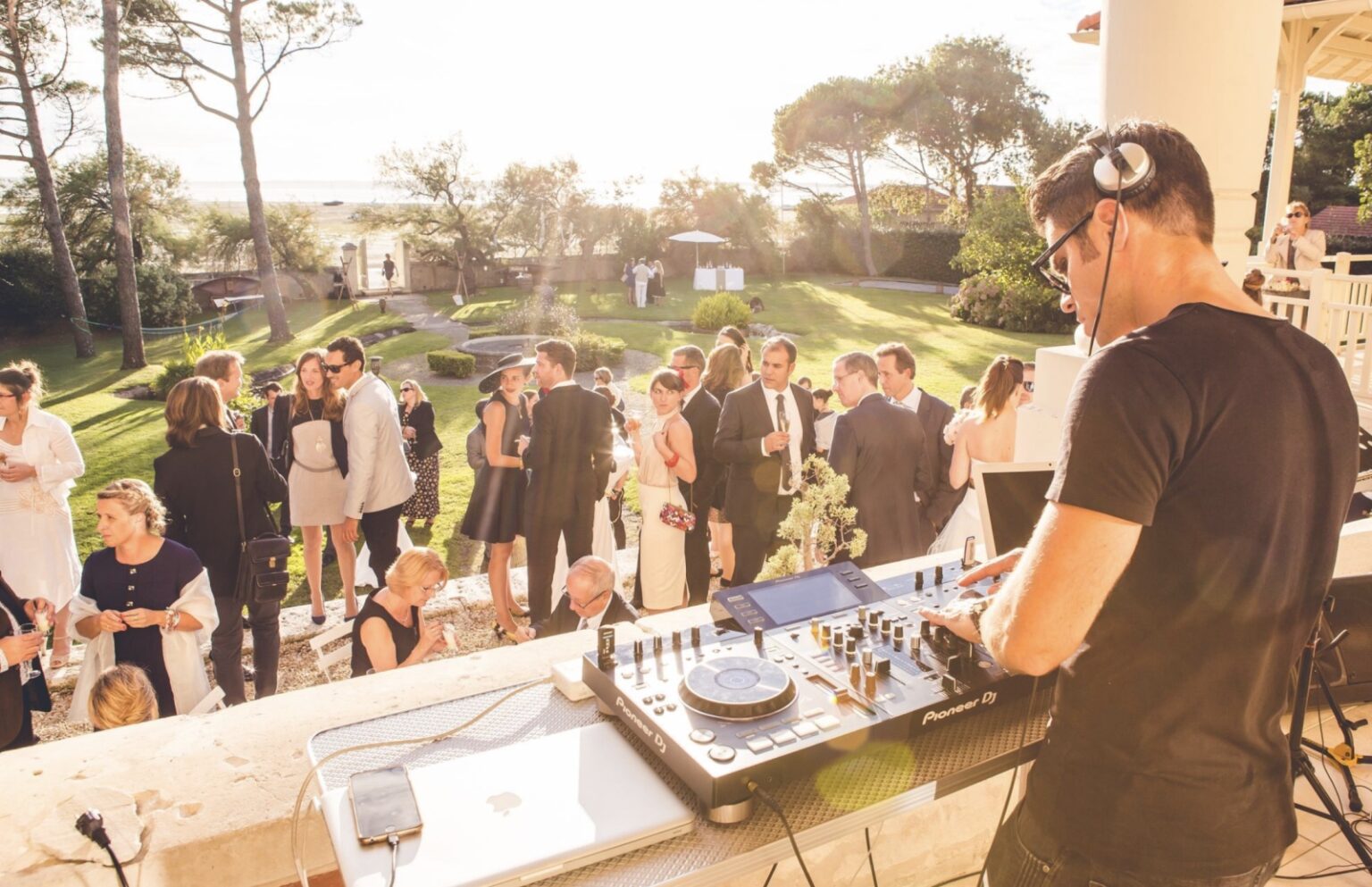 Guests and a DJ on the garden lawn at an evening event