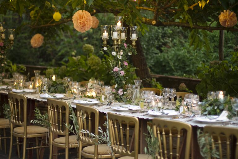 A garden reception, long table under olive trees at dusk, Villa Michaela