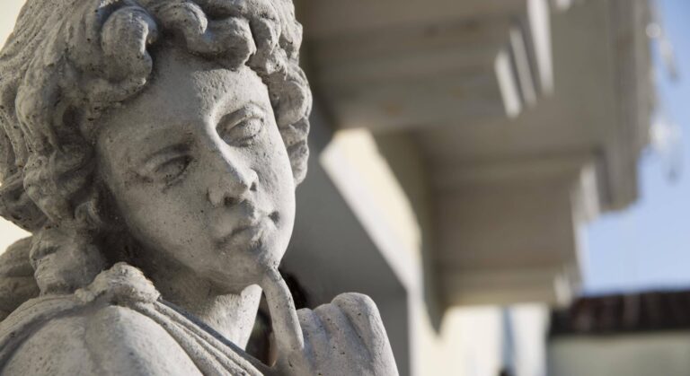 A weathered stone cherub in the park, carved curls against the villa eaves, Villa Pace Park Hotel Bolognese