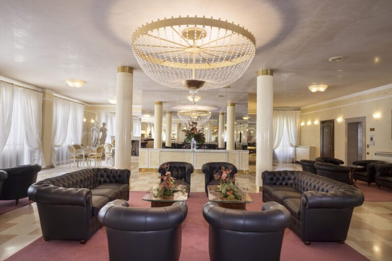 The grand villa lounge, a crystal chandelier, cream columns and deep leather Chesterfield sofas, Villa Pace Park Hotel Bolognese