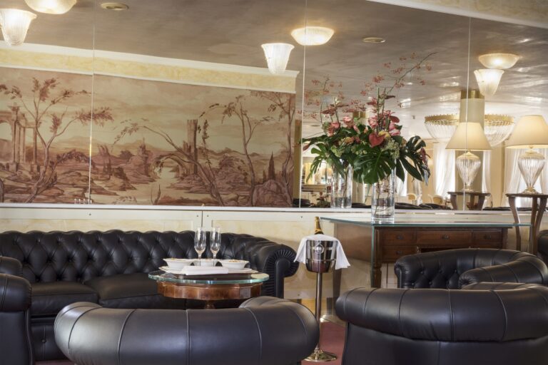 A lounge beneath a long Venetian landscape fresco, Chesterfield sofas and prosecco resting on ice, Villa Pace Park Hotel Bolognese