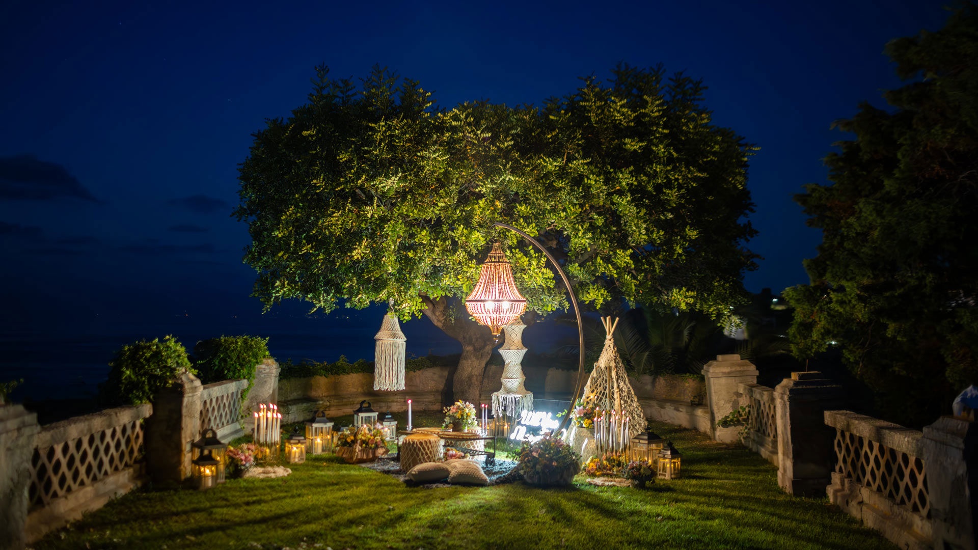 A wedding dinner on the garden terrace at dusk, Villa Paola