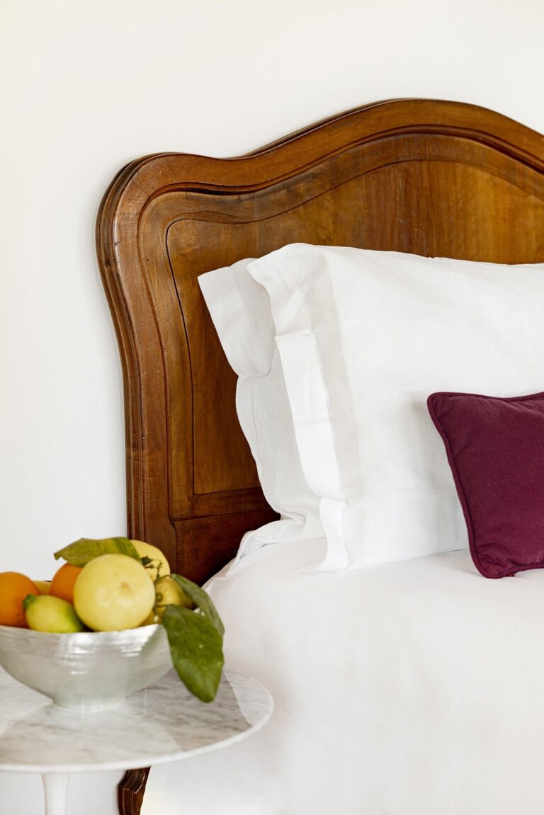 A room with a carved headboard and the morning light, Villa Paola