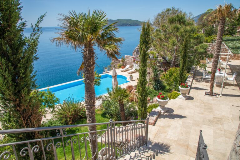 The pool terrace with palms and the sea beyond, Villa Ponta Melagrana