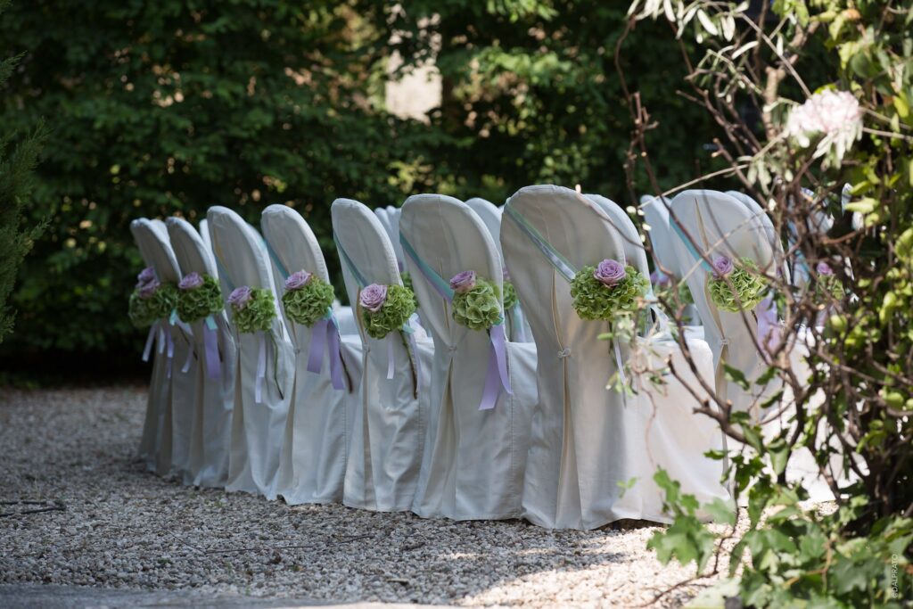 Ceremony chairs dressed with flowers on the gravel, Villa Rizzardi