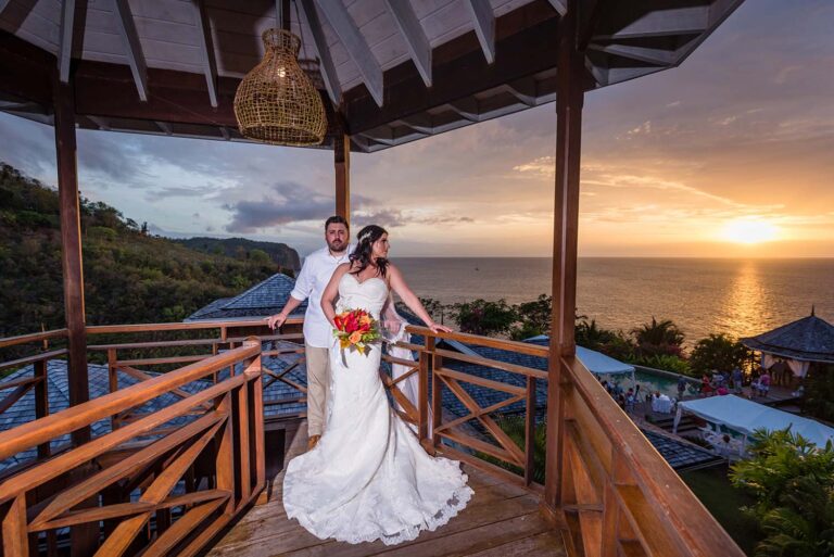 A couple on the gazebo balcony at sunset above the bay, Villa Susanna St Lucia