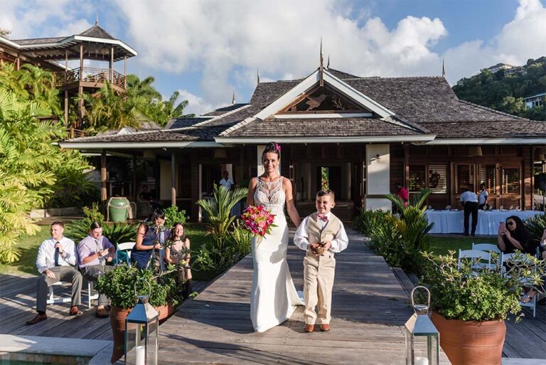 A couple and their page boy on the boardwalk with guests seated by the villa, Villa Susanna St Lucia