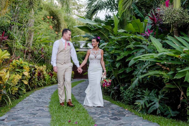 A couple walking hand in hand along a stone path through the garden, Villa Susanna St Lucia