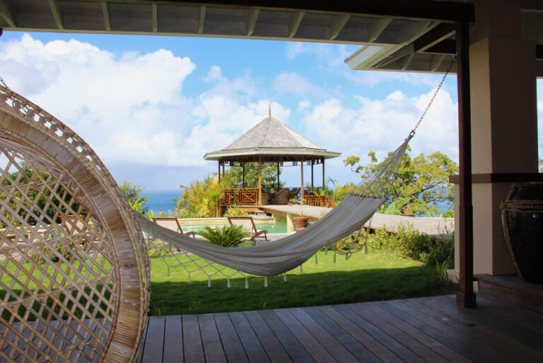 A hammock on the veranda looking across the lawn to the gazebo and sea, Villa Susanna St Lucia