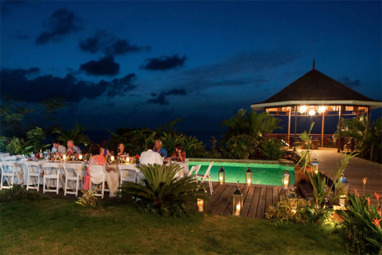 A long reception table set beside the pool at dusk, with the gazebo lit beyond, Villa Susanna St Lucia