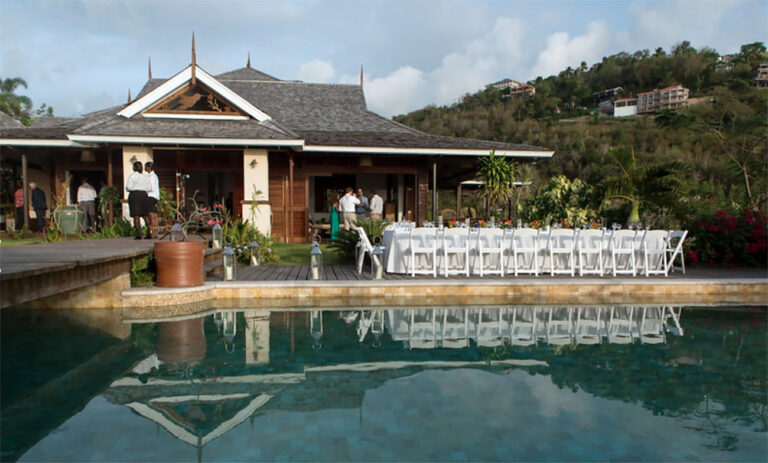 A long white-clothed table beside the pool in front of the main house, Villa Susanna St Lucia