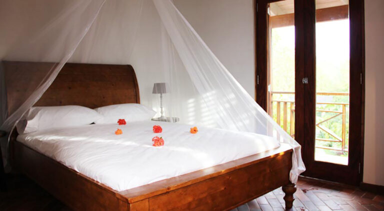 The Traveler's Palm bedroom with a sleigh bed and mosquito net, Villa Susanna St Lucia