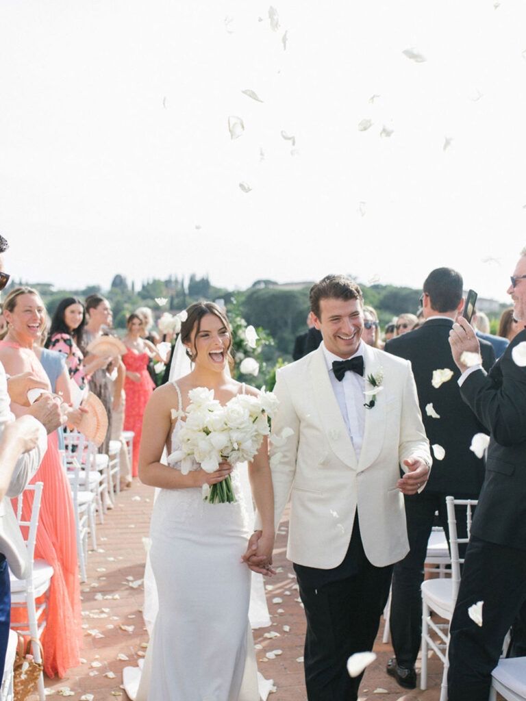 A couple leaving a ceremony on the terrace, Villa Tolomei Hotel