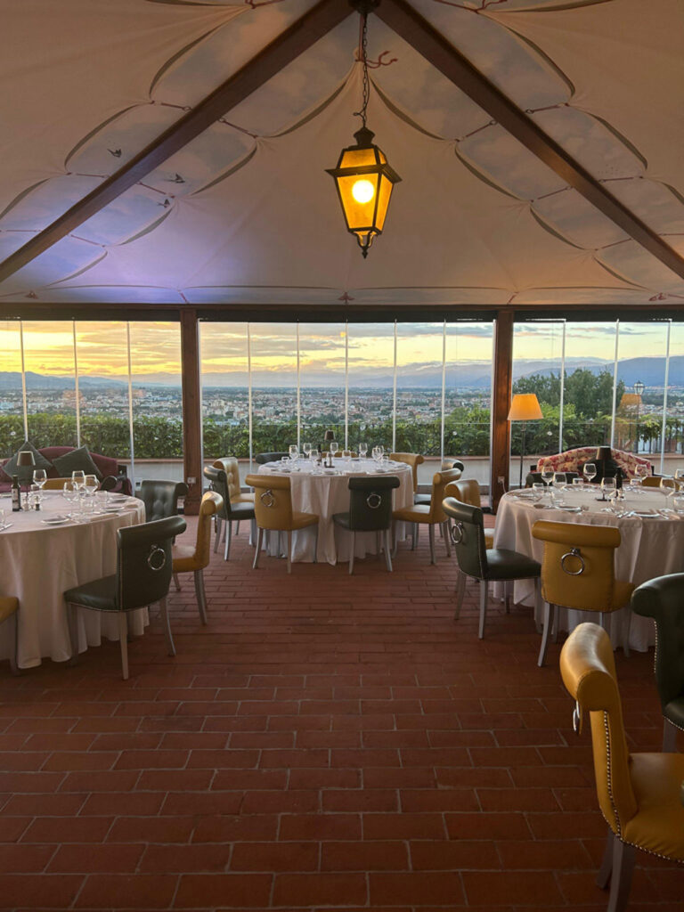 The glass-walled panoramic gazebo laid for dinner, Villa Tolomei Hotel