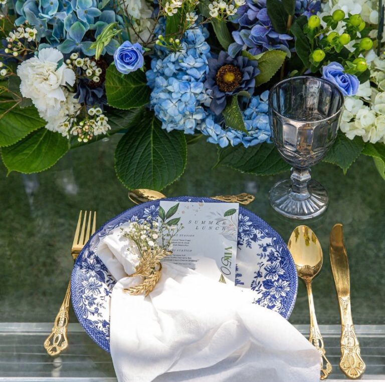 Place setting with blue and white china, gold cutlery and blue hydrangeas, Vivaah Weddings
