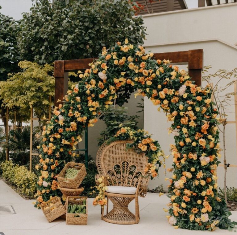 Arch of yellow roses with a peacock chair, set for a garden celebration, Vivaah Weddings