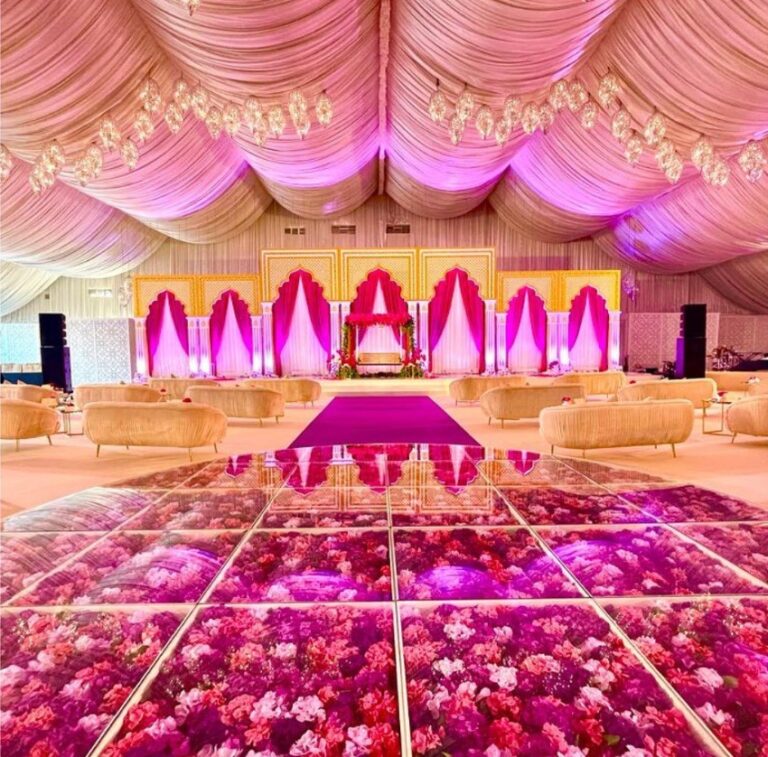 Pink and gold reception hall with an aisle of red and pink flowers set into the floor, Vivaah Weddings