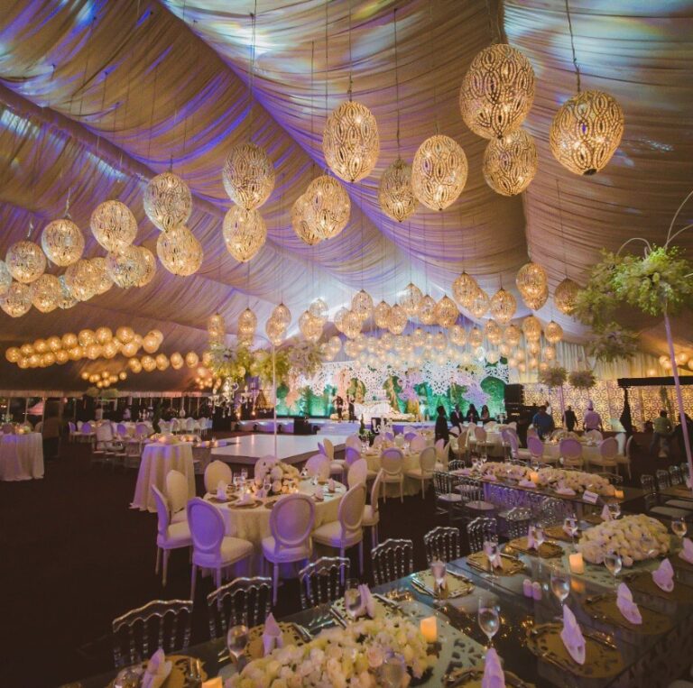 Marquee ceiling hung with gold lanterns above a candlelit dining room, Vivaah Weddings