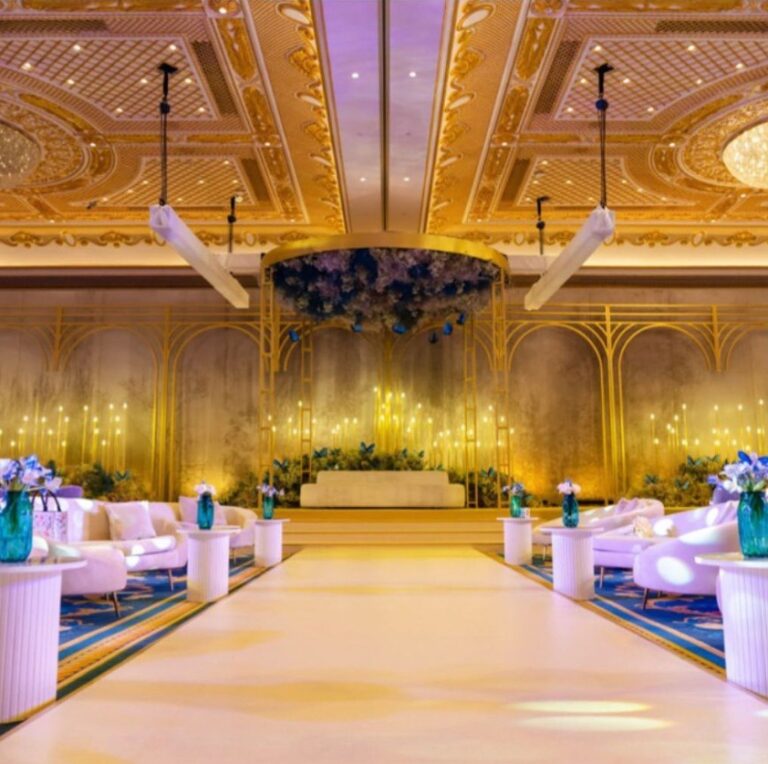 Gold and cream ballroom with a white aisle between lounge seating, Vivaah Weddings
