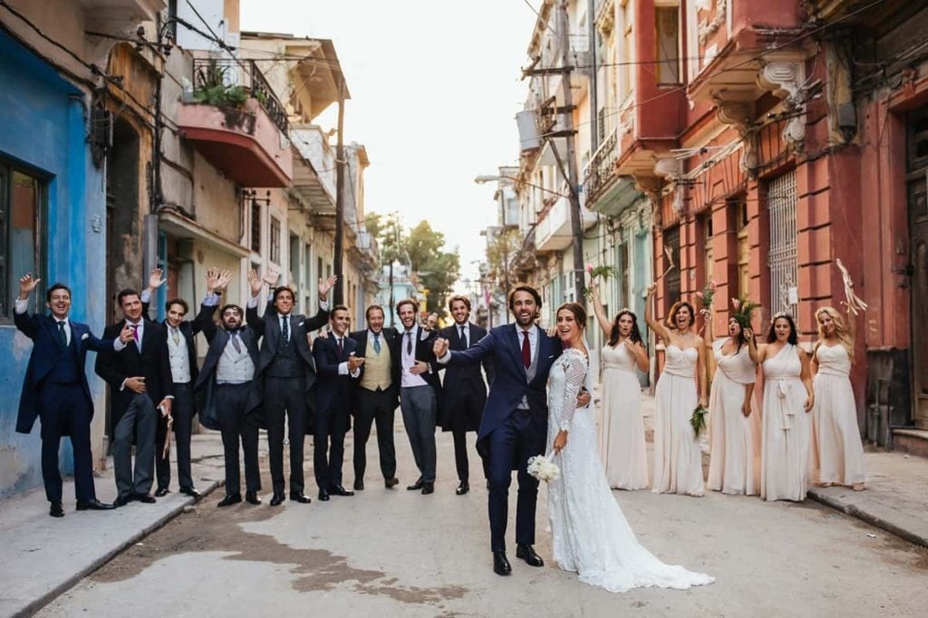 The whole wedding party, cheering, down a street the colour of Havana, Volvoreta