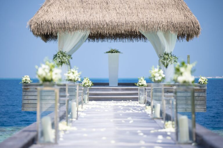 A thatched pavilion over the sea decorated with flowers for a ceremony, Waldorf Astoria Maldives Ithaafushi