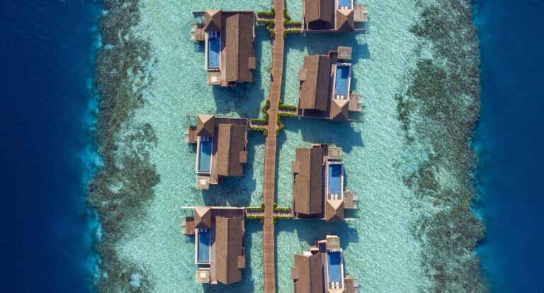 Overwater villas linked by walkways, seen from above, Waldorf Astoria Maldives Ithaafushi