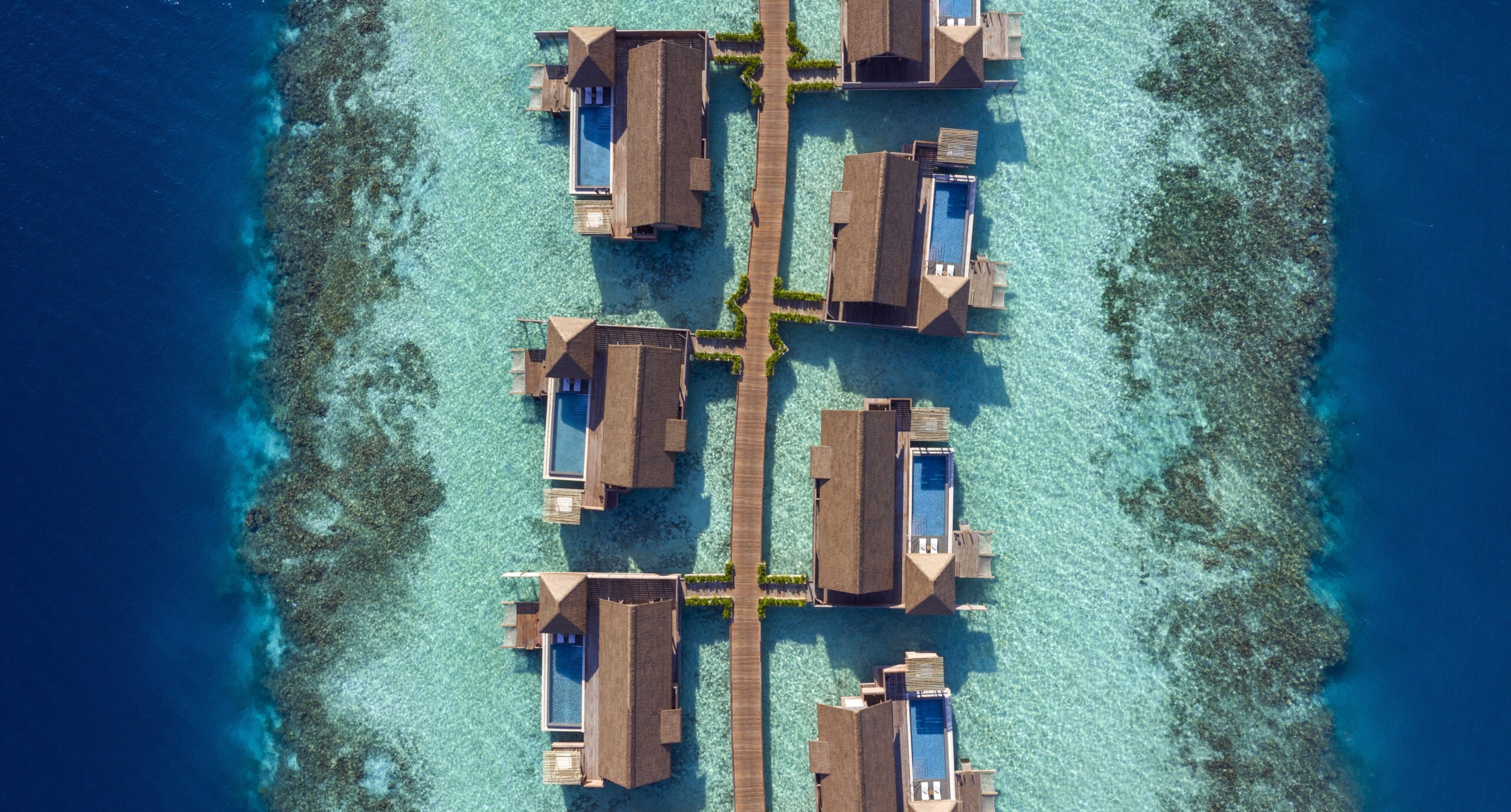 Overwater villas linked by walkways, seen from above, Waldorf Astoria Maldives Ithaafushi