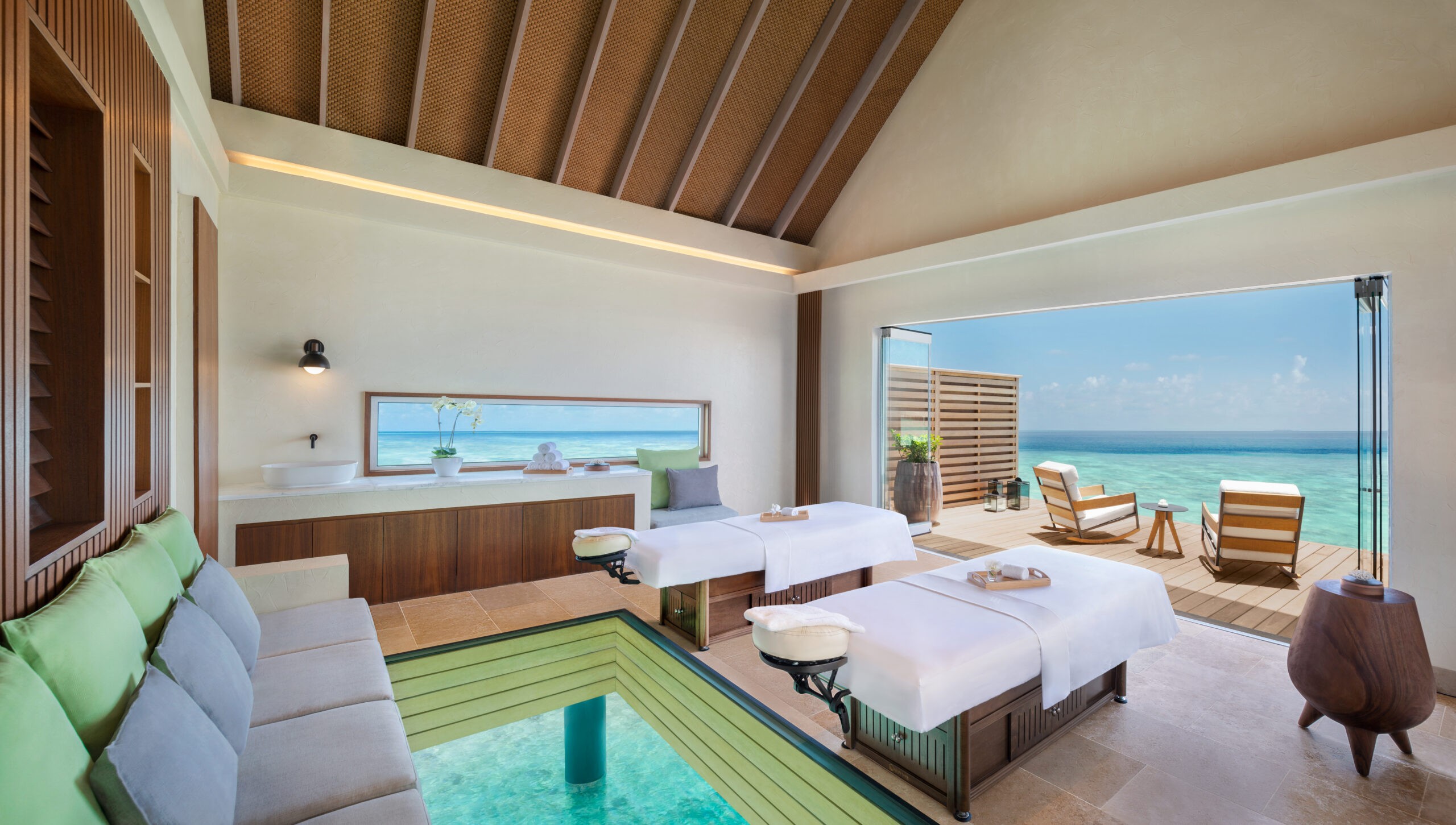 A treatment suite with a glass floor panel over the lagoon, Waldorf Astoria Maldives Ithaafushi