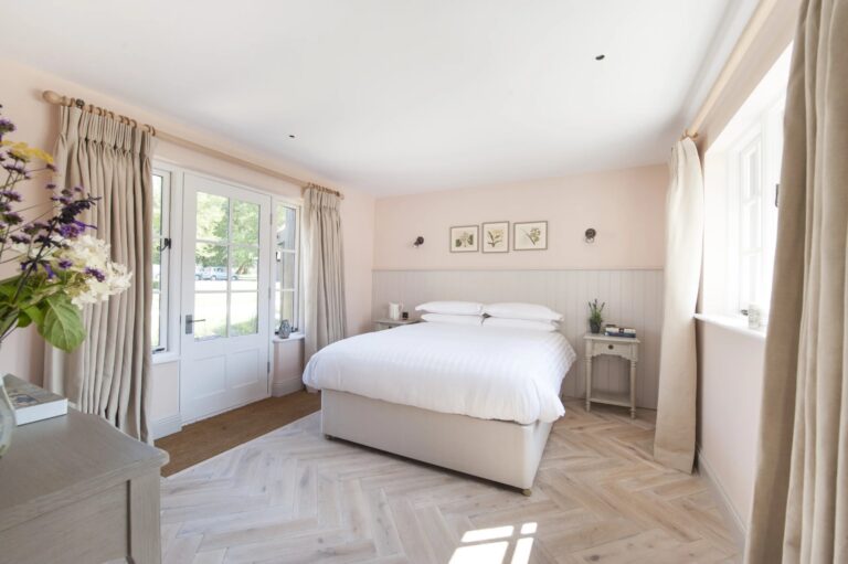 A light guest bedroom with a double bed, parquet floor and French doors onto the garden, Wasing Park Weddings