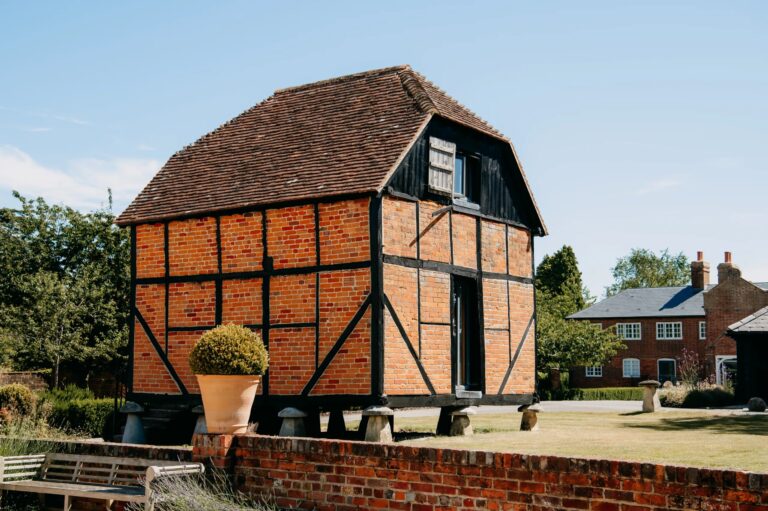The timber-framed Granary raised on its staddle stones, now a suite, Wasing Park Weddings