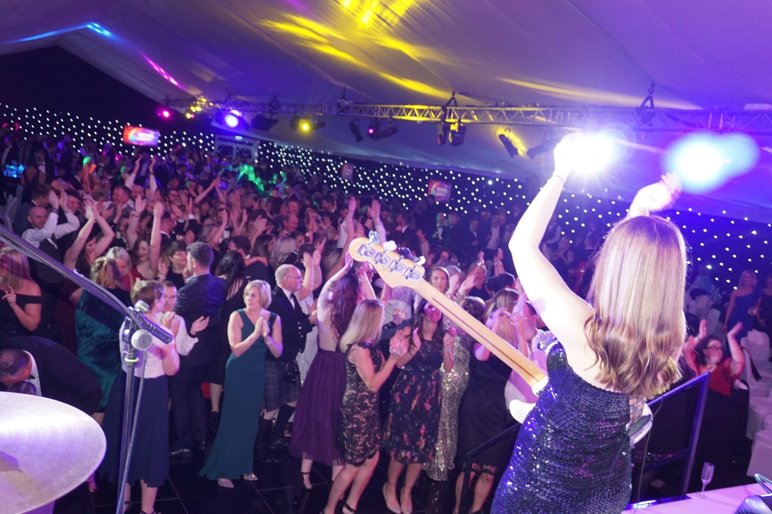 The band on stage with guests dancing beneath a starlit ceiling, Waterfront