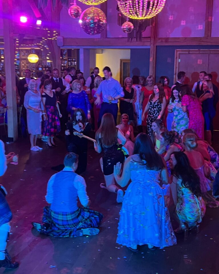 Guests gathered in a circle on the dance floor, several in kilts, Waterfront