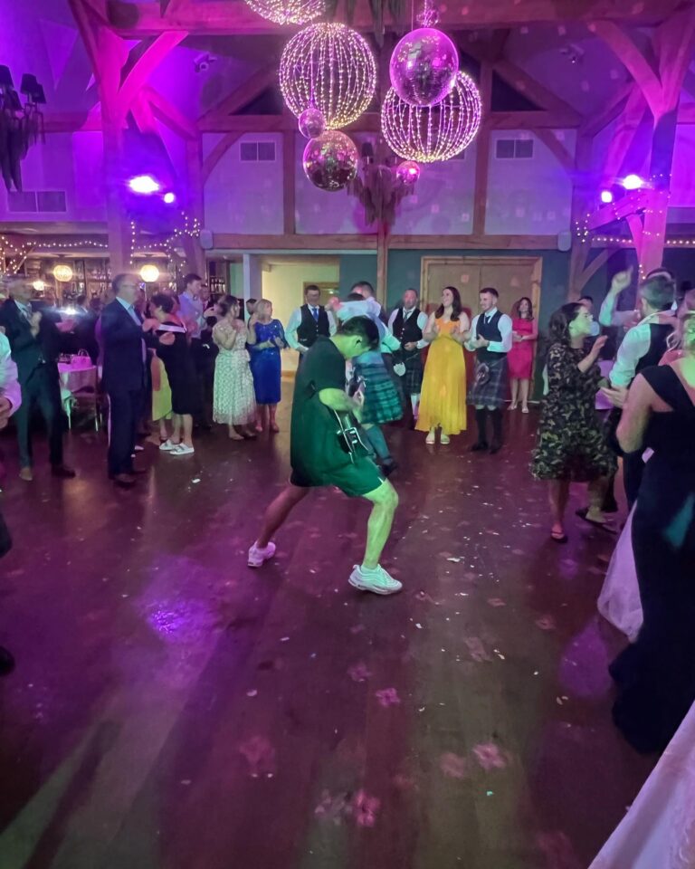 A full dance floor beneath hanging globe lights and mirror balls, Waterfront
