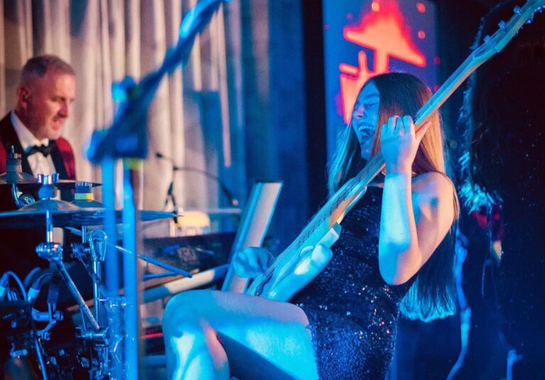 A bass player and a vocalist performing for guests at dinner tables, Waterfront