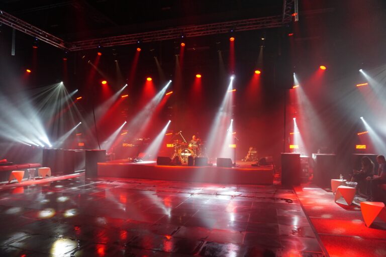 A stage with red and white lighting rig and haze, Waterfront