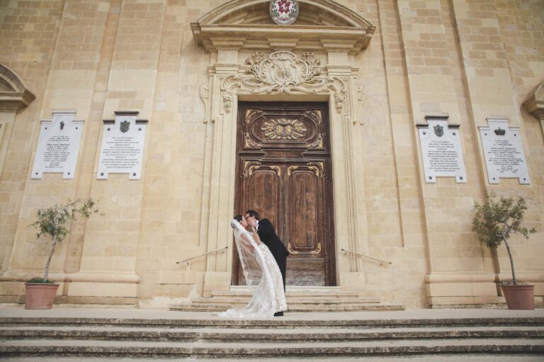 Couple kissing on the steps of a baroque church doorway, Wed In Malta
