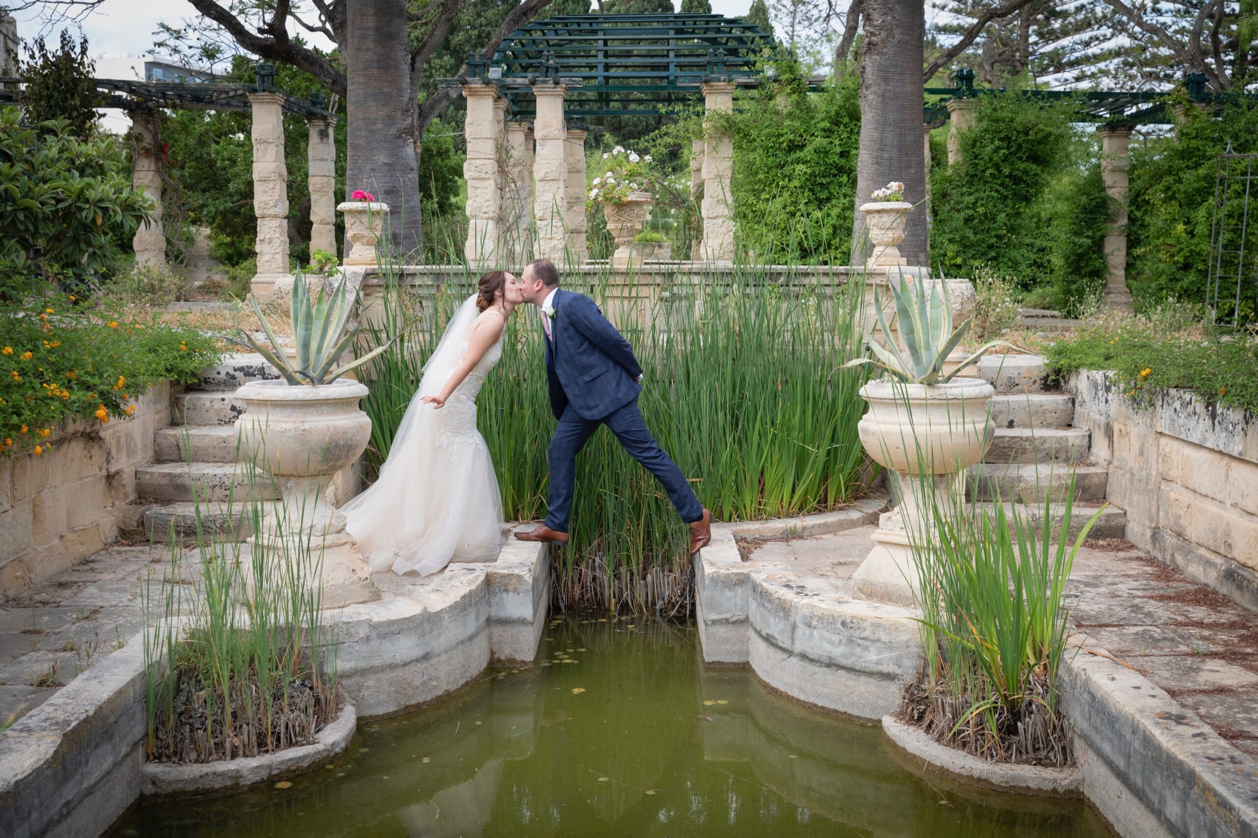 A kiss between stone planters in a formal water garden, Wed In Malta