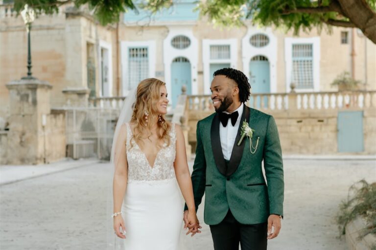 Bride and groom hand in hand in a palazzo forecourt, Wed In Malta