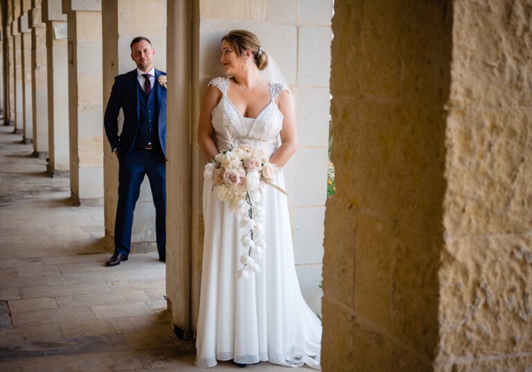 Couple in a limestone cloister, bride with a cascading bouquet, Wed In Malta