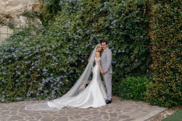 Bride in a long veil against flowering plumbago, Wed In Malta