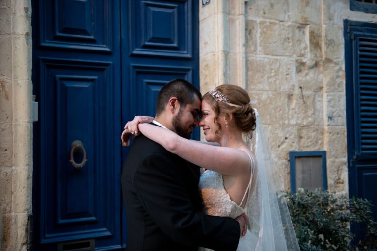 Couple embracing in front of a navy Maltese door, Wed In Malta