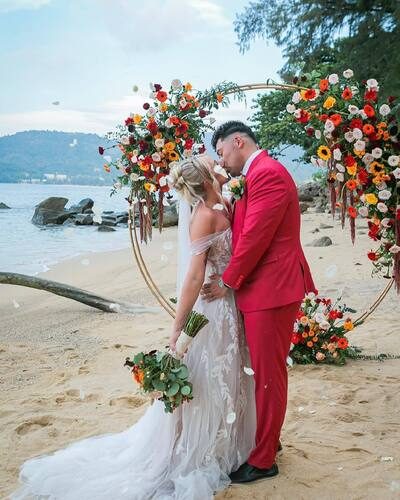 Couple under a circular floral arch on a Phuket beach, Wedding Celebrant Phuket - Paul Cunliffe