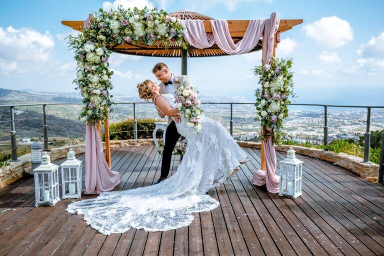 A couple at the floral arch on the Umbrella Deck at Villa Panorama, Wedding Cyprus Villas