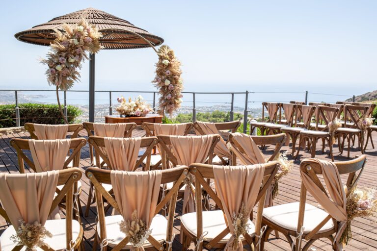 Ceremony chairs with ribbon sashes under the thatched umbrella, Wedding Cyprus Villas