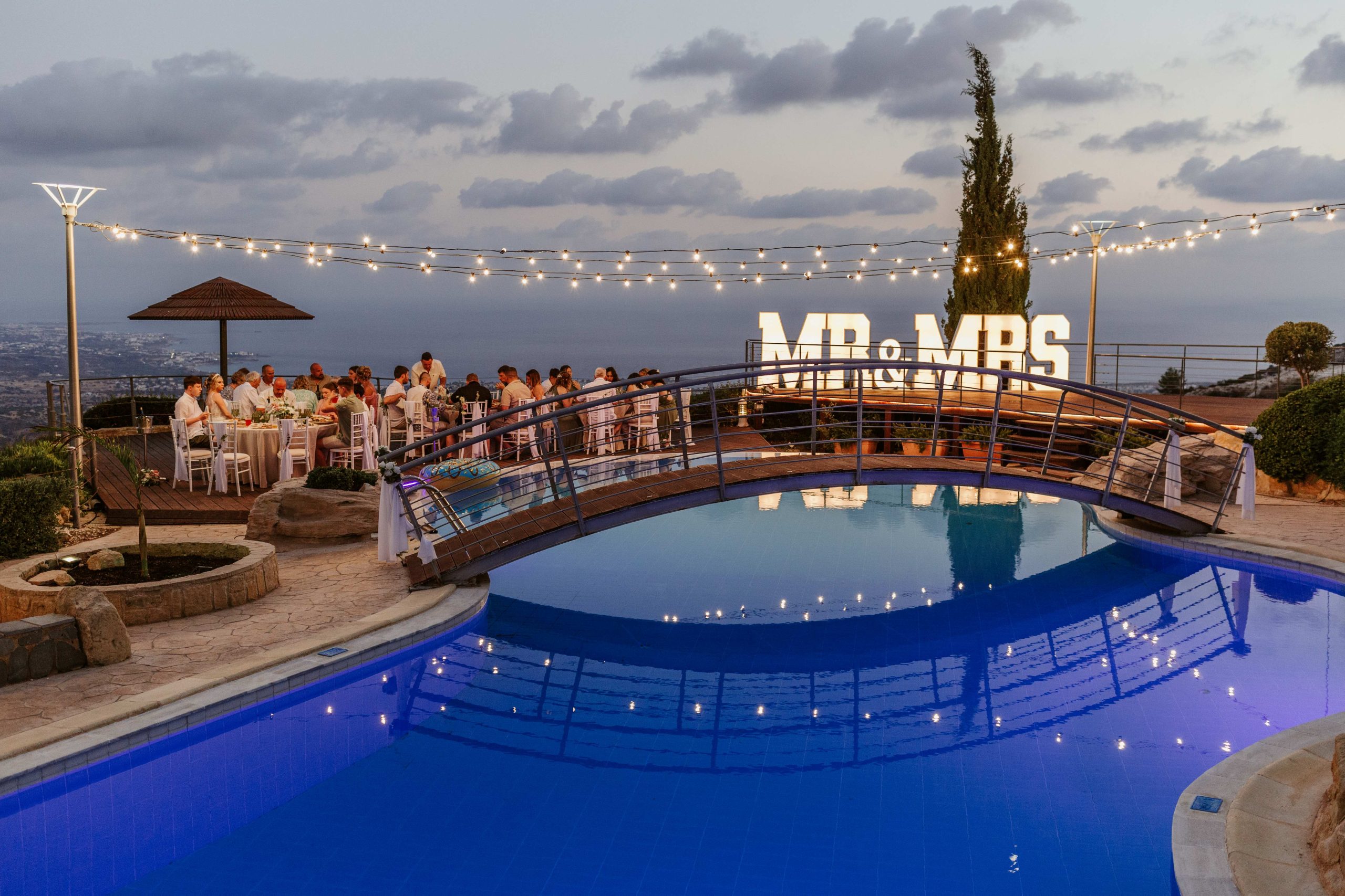 Villa Panorama at dusk, the pool bridge and the terrace set for dinner, Wedding Cyprus Villas