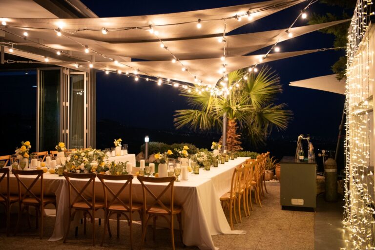 A long dinner table under festoon lights on the Oceania terrace, Wedding Cyprus Villas