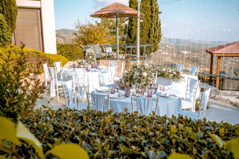 Round tables set among the garden planting at Villa Panorama, Wedding Cyprus Villas