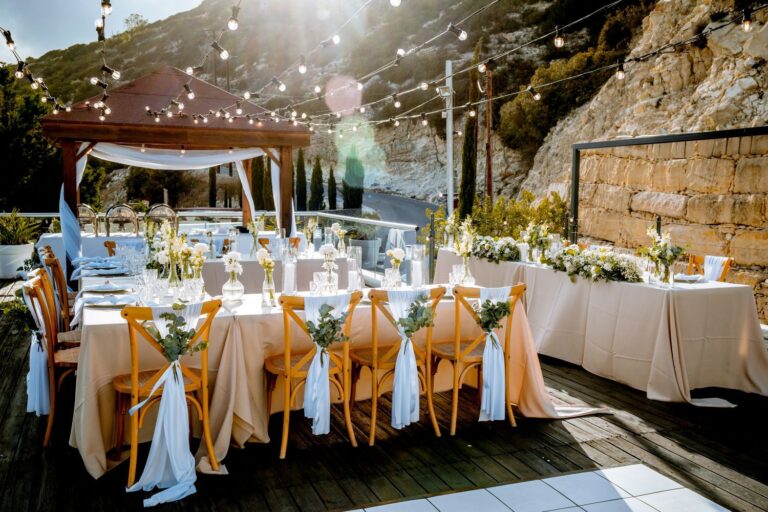 A reception table dressed with ribbons under a wooden pergola, Wedding Cyprus Villas