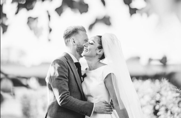 Black and white, a bride and groom laugh nose to nose, veil in the breeze, Wedding Hair And Makeup By Lisa