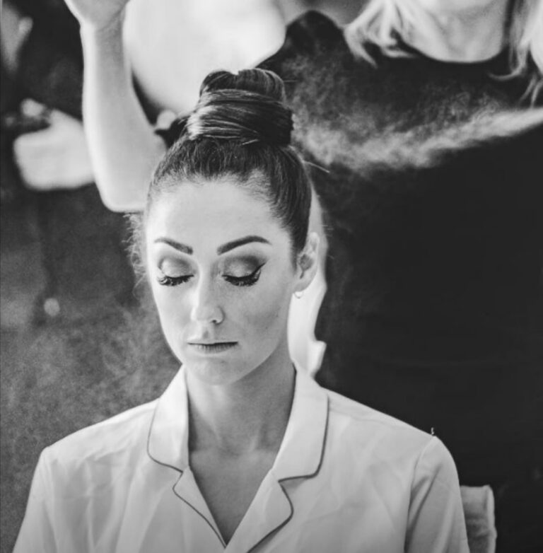 Black and white, a bride's top-knot finished with hairspray, eyes closed, Wedding Hair And Makeup By Lisa